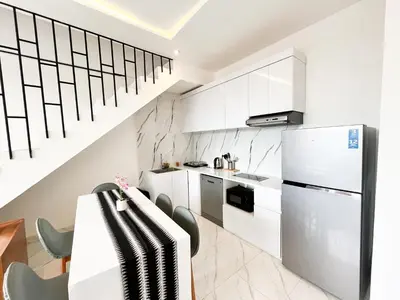 a kitchen with white cabinets and a white refrigerator at Villa Arti in Seminyak