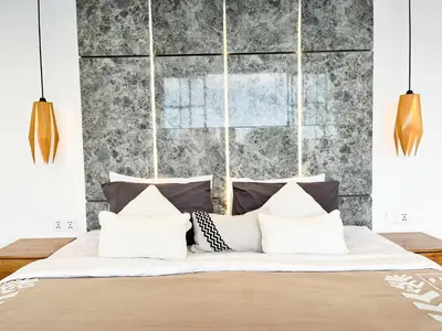 a bedroom with a large bed with white pillows at Villa Arti in Seminyak