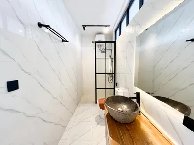 a bathroom with a stone sink and a tub at Villa Arti in Seminyak