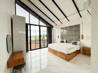 a bedroom with a bed and large windows at Villa Arti in Seminyak