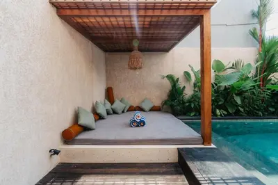 a bed in a room next to a swimming pool at Villa Bens Luxury - 3BR Villa in Kerobokan in Kerobokan