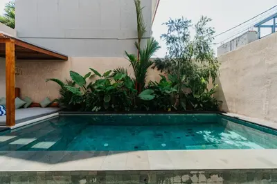 a swimming pool in front of a building with plants at Villa Bens Luxury - 3BR Villa in Kerobokan in Kerobokan