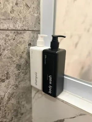 a black soap bottle sitting on a window sill at Flamboyant Guesthouse in Seminyak