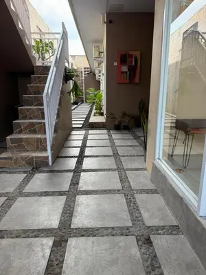 a walkway in a house with a tile floor at Flamboyant Guesthouse in Seminyak