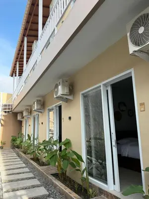 a row of houses with a balcony and a bed at Flamboyant Guesthouse in Seminyak