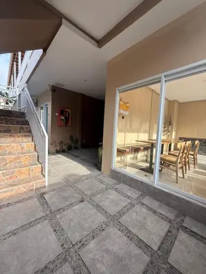 a patio with a table and a large glass window at Flamboyant Guesthouse in Seminyak