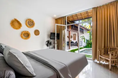 a bedroom with a bed and a large window at Davion 6 BR Private Pool Villa in Seminyak