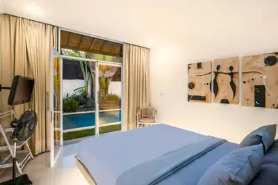 a bedroom with a bed and a view of a pool at Davion 6 BR Private Pool Villa in Seminyak
