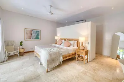 a bedroom with a bed and a couch and a chair at Villa Meya 3 Bedroom Villa in Central Seminyak in Seminyak