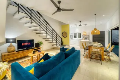 a living room with a blue couch and a table at Villa Meya 3 Bedroom Villa in Central Seminyak in Seminyak
