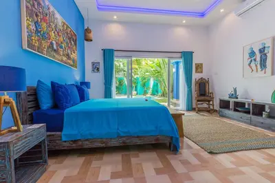 a blue bedroom with a bed and a couch at Villa Kanari,5 bed & pool in Seminyak
