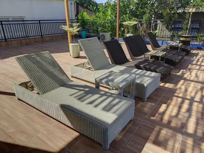 a row of chairs and tables on a patio at Villa Kanari,5 bed & pool in Seminyak