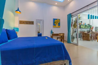 a bedroom with a blue bed and a dining room at Villa Kanari,5 bed & pool in Seminyak