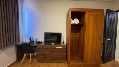 a room with a desk with a television and a cabinet at Villa Lans By Baliem Villa in Jimbaran
