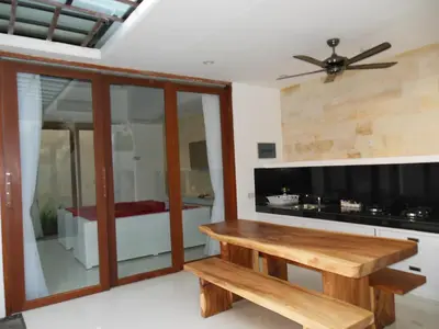 a living room with a wooden table and a couch at HK Villa Bali in Legian