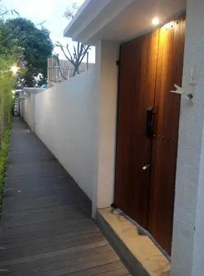 a hallway with a wooden door on the side of a building at HK Villa Bali in Legian
