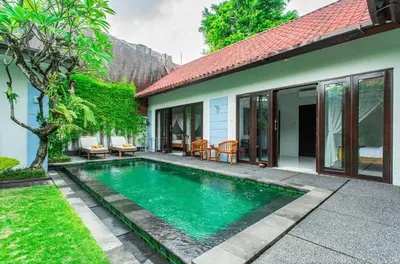 a swimming pool in front of a house at Abimanyu Villa 2 Seminyak in Seminyak