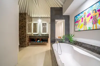 a bathroom with a tub and a painting on the wall at Ocean Two 1BR Villa Honeymoon Seminyak in Seminyak