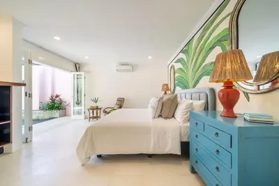a bedroom with a bed with a blue dresser and a mirror at Ocean Two 1BR Villa Honeymoon Seminyak in Seminyak