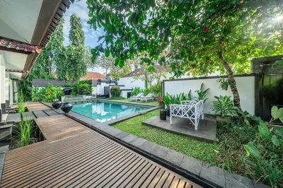 a backyard with a swimming pool and a wooden deck at Ocean Two 3BR Private Pool in Oberoi Seminyak in Seminyak