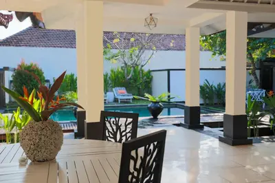 a dining room table with chairs and a view of a pool at Ocean Two 3BR Private Pool in Oberoi Seminyak in Seminyak