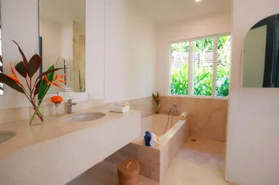 a bathroom with a tub and a sink and a window at Ocean Two 3BR Private Pool in Oberoi Seminyak in Seminyak
