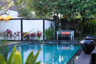 a pool with a bench next to a fence at Ocean Two 3BR Private Pool in Oberoi Seminyak in Seminyak