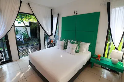 a bedroom with a large white bed with a green headboard at Ocean Two 3BR Private Pool in Oberoi Seminyak in Seminyak