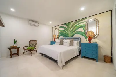 a bedroom with a bed with a painting on the wall at Ocean Two 4BR Family Retreat Oberoi in Seminyak