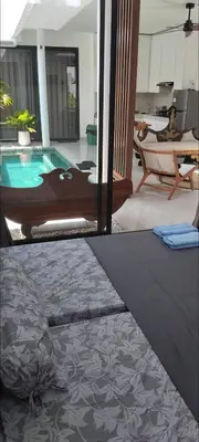 a living room with a swimming pool in a house at Serene Bali Villa with Private Pool and Antiqued Charm in Balian