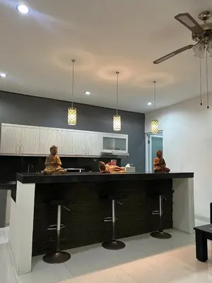 two people sitting at a counter in a kitchen at Villa Goodison - Two Bedrooms in Legian