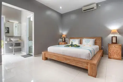a bedroom with a large bed and a bathroom at Villa Goodison - Two Bedrooms in Legian