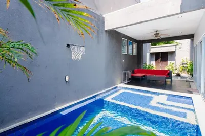 a swimming pool in a house with a basketball hoop at Villa Goodison - Two Bedrooms in Legian