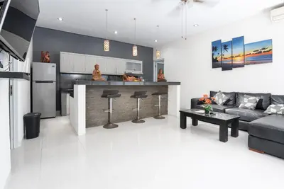 a living room with a couch and a kitchen at Villa Goodison - Two Bedrooms in Legian