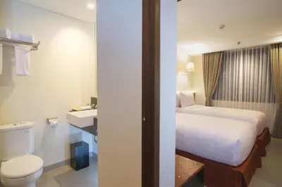 a hotel room with a bed and a toilet at Savvoya Hotel Seminyak in Seminyak