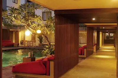 a hotel room with a pool and a bedroom with a bed at Savvoya Hotel Seminyak in Seminyak