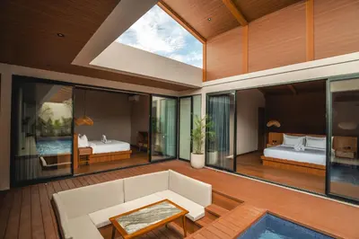 a living room with a couch and a bedroom at Kinama Villa Jimbaran Bali in Jimbaran