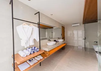 a bathroom with a sink and a mirror at Kinama Villa Jimbaran Bali in Jimbaran