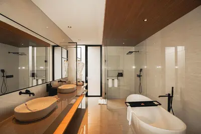 a bathroom with three sinks and a tub and a bath tub at Kinama Villa Jimbaran Bali in Jimbaran