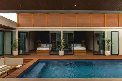 a villa with a swimming pool and a bedroom at Kinama Villa Jimbaran Bali in Jimbaran
