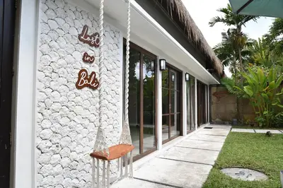 a building with a hanging sign on the side of it at Casa Veluna - Seminyak in Seminyak