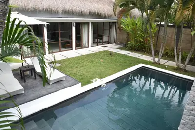 a swimming pool in front of a villa at Casa Veluna - Seminyak in Seminyak