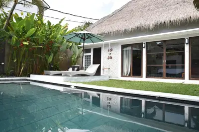 a villa with a swimming pool and a house at Casa Veluna - Seminyak in Seminyak