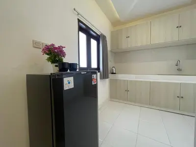 a kitchen with a black refrigerator and a sink at Mopoe Guesthouse in Sanur