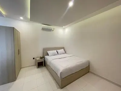 a small bedroom with a bed and a night stand at Mopoe Guesthouse in Sanur