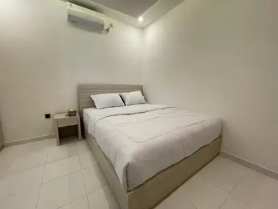 a small bedroom with a bed with a night stand at Mopoe Guesthouse in Sanur