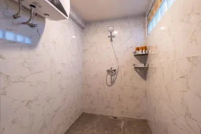 a bathroom with a shower with white marble walls at JB Hazel, 4Bedroom villa in Jimbaran in Jimbaran