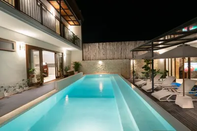 a large swimming pool with chairs and an umbrella at JB Hazel, 4Bedroom villa in Jimbaran in Jimbaran