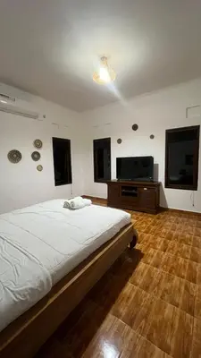 a bedroom with a bed and a flat screen tv at 2 Bedrooms Private Pool Villa Indi K Kerobokan in Seminyak