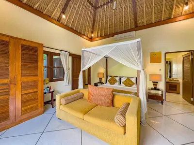 a bedroom with a bed and a couch in a room at Luxury 4BR - Villa Santai - Central Seminyak in Seminyak